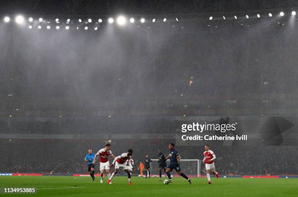 Rains falls as Anthony Martial of Manchester United tries to break through during the Premier League match between Arsenal FC and Manchester United...