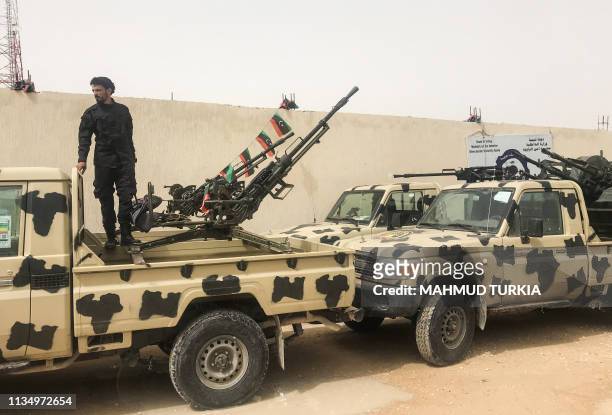 Local militiaman, belonging to a group opposed to Libyan strongman Khalifa Haftar, stands on an armoured vehicle the group said they seized from...