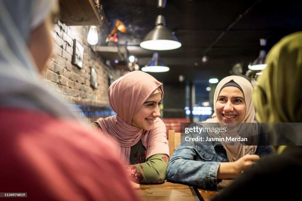 Arab teenage girls having fun together in restaurant