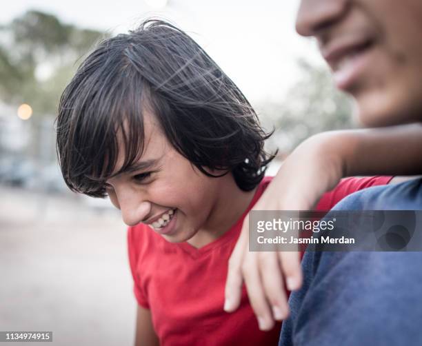 Two teenage candid boys laughing outdoors