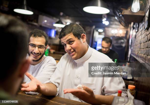 middle eastern boys having conversation at restaurant - chubby arab stock pictures, royalty-free photos & images