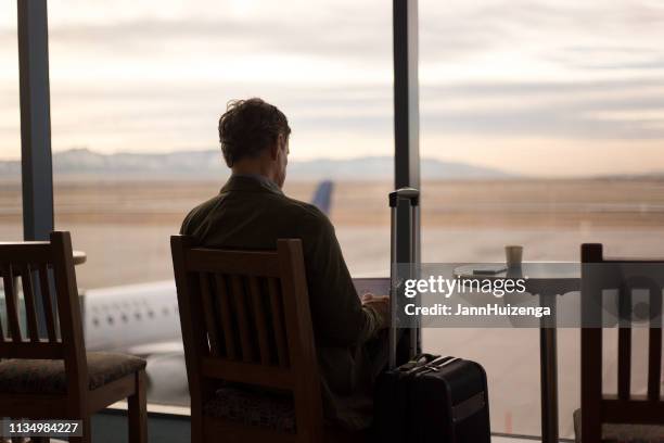 flughafen: mann in abflughunung; flugzeug auf tarmac - wheeled luggage stock-fotos und bilder