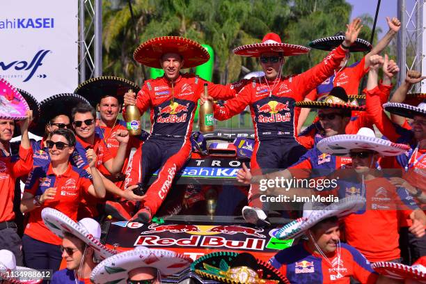 Sebastien Ogier of France and Julien Ingrassia of France celebrate with teammates in their Citroen Total WRT after their victory during day three of...