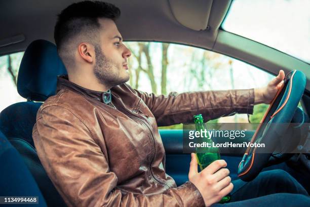 man holding bottle of beer while driving car - drunk driving accident stock pictures, royalty-free photos & images