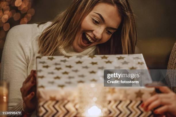 excited woman opening a present - christmas gift stock pictures, royalty-free photos & images