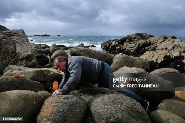 Christian Kervelle-Lety, a voluntary of the French association Ar Viltansou searches near the entry of a partially submerged cave only accessible at...