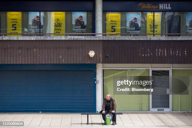 Shopper sits on a bench in front of closed down stores in Basildon, U.K., on Friday, April 5, 2019. Billionaire Mike Ashley and Retail tycoon Philip...
