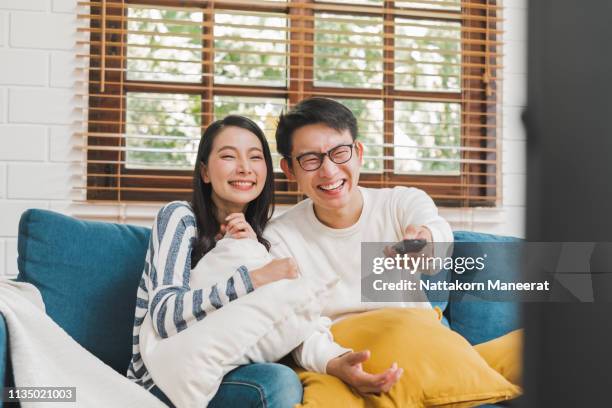 Asian couple lifestyle, man and woman watching TV movies at home, family lifestyle relax and recreation concept