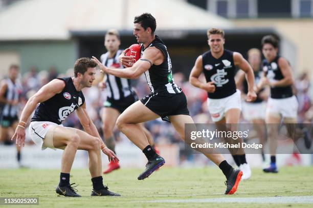 Scott Pendlebury of the Magpies runs with the ball from Marc Murphy of the Blues during the 2019 JLT Community Series match between the Collingwood...