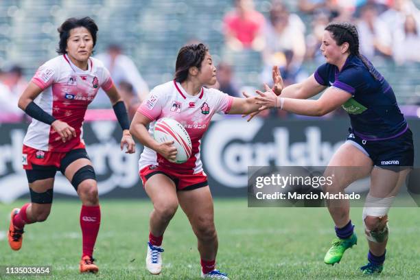 Abi Evans of Scotland tries to put a tackle on Yume Okuroda of Japan on day one of the Cathay Pacific/HSBC Hong Kong Sevens Semi-Final match between...