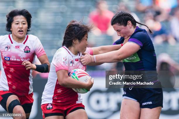 Abi Evans of Scotland tries to put a tackle on Yume Okuroda of Japan on day one of the Cathay Pacific/HSBC Hong Kong Sevens Semi-Final match between...