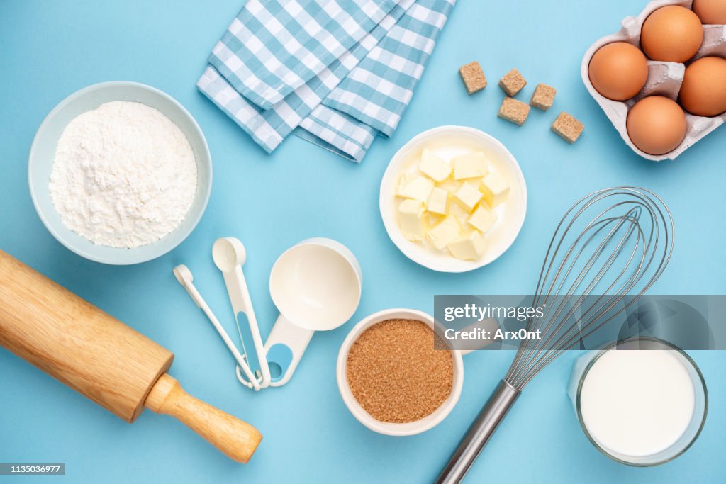 Kitchen utensils and baking ingredients on blue background