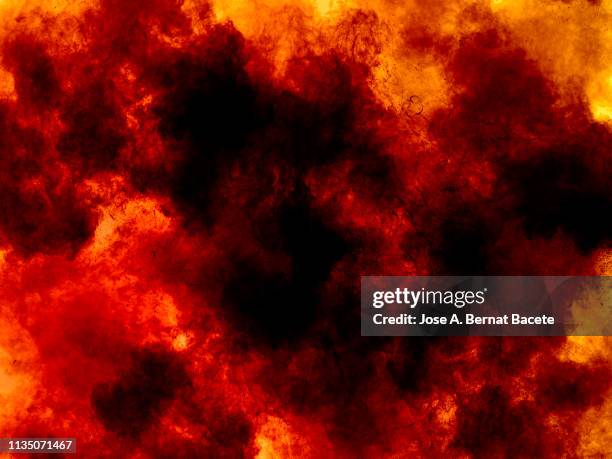 explosion by an impact of a cloud of particles of powder and smoke of color orange and yellow on a black background. - fantasy fire stock pictures, royalty-free photos & images