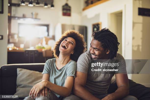 young cheerful african american couple in the living room. - young adult couple stock pictures, royalty-free photos & images