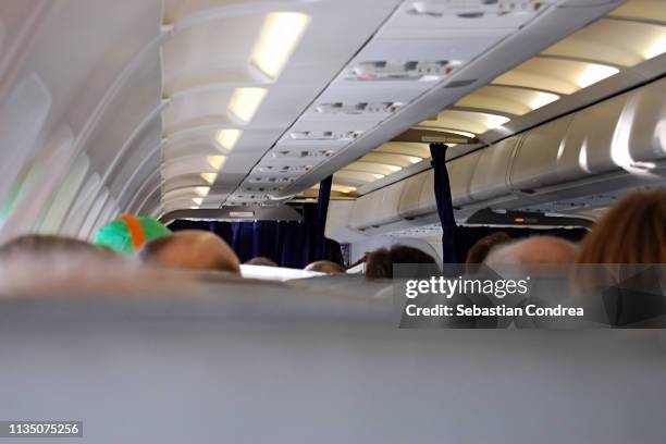 commercial aircraft cabin with passengers going on the seul. south korea - crowded plane stock pictures, royalty-free photos & images