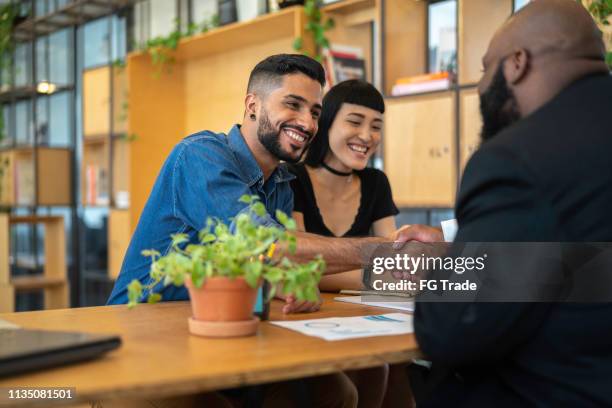 consultant / agent and clients on a handshake at business meeting - lawyer handshake stock pictures, royalty-free photos & images