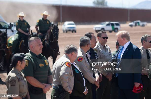 President Donald Trump speaks with members of the US Customs and Border Patrol as he tours the border wall between the United States and Mexico in...