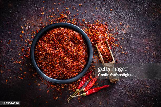 red chili pepper flakes shot from above - cayenne powder stock pictures, royalty-free photos & images