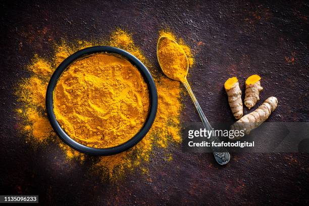 gewürze: kurmäre wurzeln und pulver von oben - indian curry stock-fotos und bilder