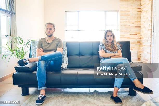 too much pride to apologise - couple couch imagens e fotografias de stock