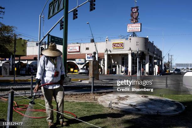 Worker waters grass near the U.S.-Mexico border in Mexicali, Mexico, on Friday, April 5, 2019. U.S. President Donald Trump said the U.S. Is "full" of...