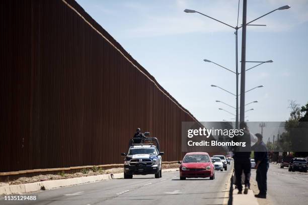 Mexican Federal Police patrol along a fence ahead of U.S. President Donald Trump's visit to Calexico, California, across from the U.S.-Mexico border...
