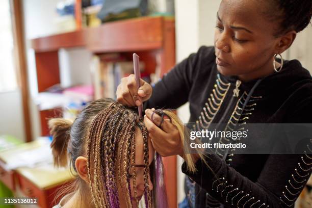 african woman styling friend's hair - hair extensions stock pictures, royalty-free photos & images