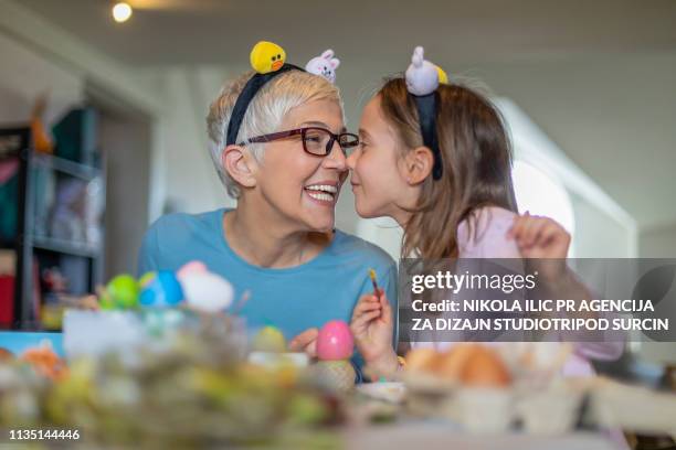 easter concept. happy beautiful little girl and gray hair grandmother prepare chicken eggs for holiday - easter family stock pictures, royalty-free photos & images
