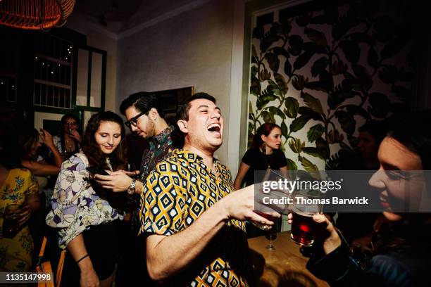 laughing friends toasting during party in night club - boum photos et images de collection