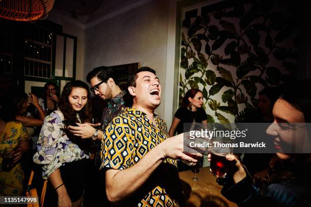 laughing friends toasting during party in night club - party foto e immagini stock