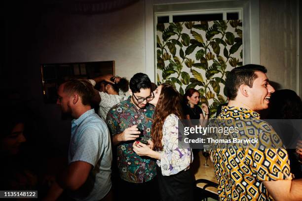 woman kissing boyfriend on cheek during date in night club - flirten stockfoto's en -beelden
