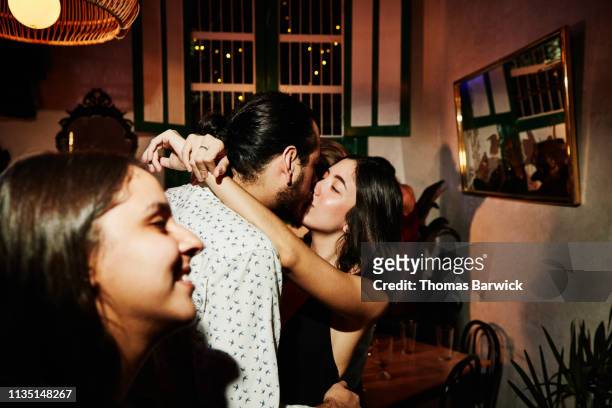 couple kissing during party with friends in night club - der kuss stock-fotos und bilder