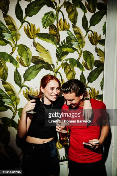laughing couple embracing in night club - funny love stock-fotos und bilder