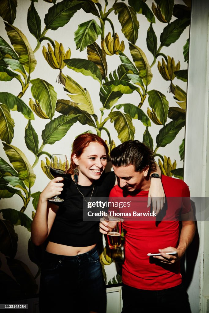Laughing couple embracing in night club