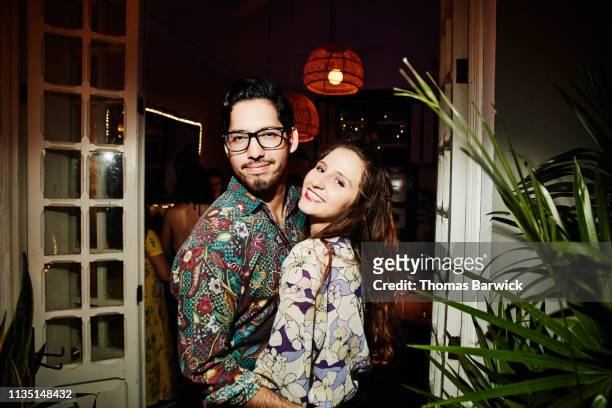 portrait of smiling embracing couple on date in night club - hemd aufreißen stock-fotos und bilder