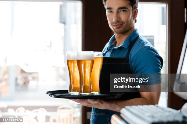 barkeeper mit biergläsern in der brauerei - kellner tablett stock-fotos und bilder