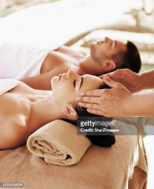 couples ayant la thérapie de pierre chaude extérieure - masser photos et images de collection