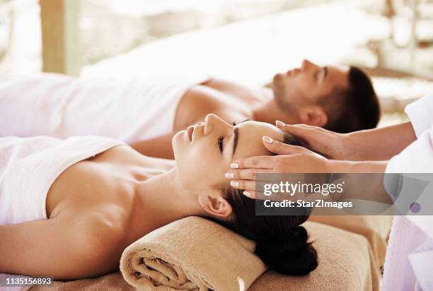 couple having outdoor hot stone therapy - massage couple stock pictures, royalty-free photos & images