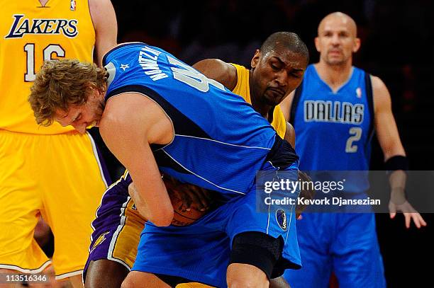 Dirk Nowitzki of the Dallas Mavericks holds onto the ball as Ron Artest of the Los Angeles Lakers attempts to steal it in the first quarter of Game...