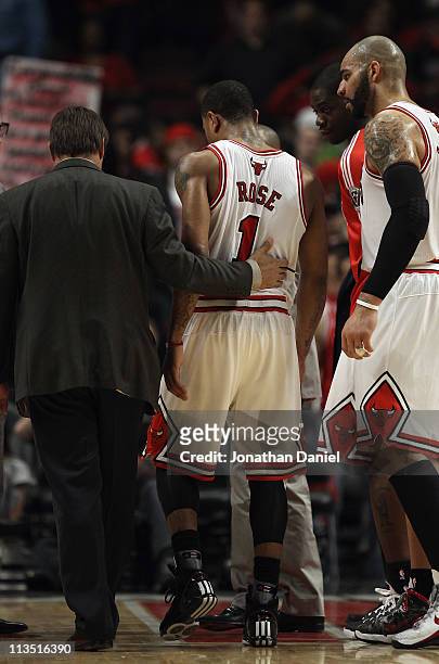 Derrick Rose of the Chicago Bulls is helped off of the court by trainer Fred Tedeschi and Carlos Boozer after a loss to the Atlanta Hawks in Game One...
