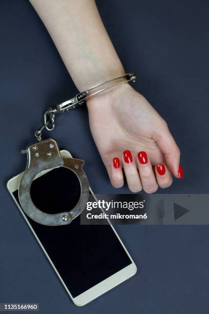 handcuffed to phone addiction - handcuffs imagens e fotografias de stock