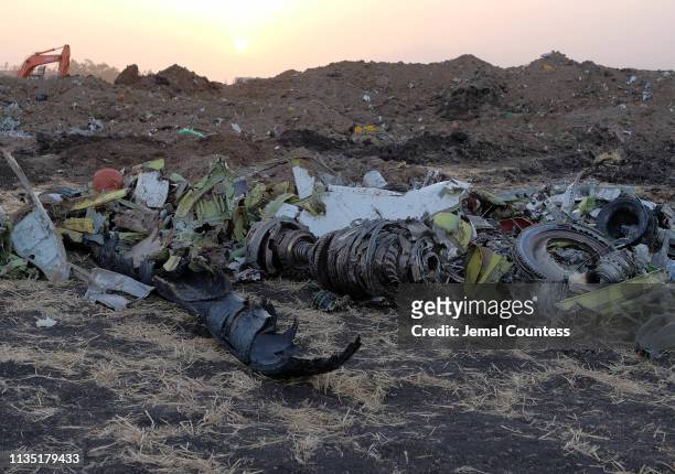 Parts of an engine and the landing gear lie in a pile after being gathered by workers during the continuing recovery efforts at the crash site of...