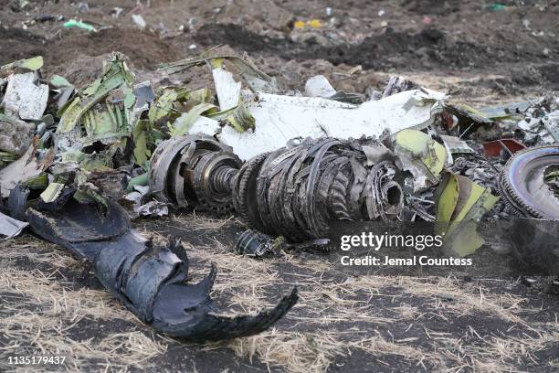 Parts of an engine and landing gear lie in a pile after being gathered by workers during the continuing recovery efforts at the crash site of...