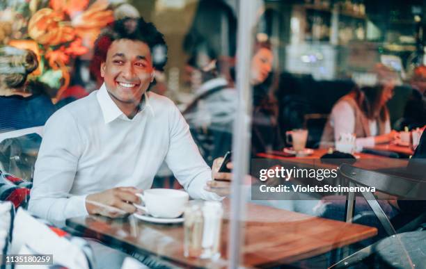 man with a phone in a coffee shop - enjoying coffee cafe morning light stock pictures, royalty-free photos & images