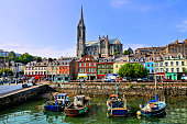 Colorful buildings, old boats and cathedral, Cobh harbor, County Cork, Ireland