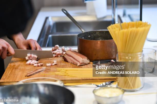 One of the chefs of the traditional team prepare the traditional famous Italian pasta dish "spaghetti alla carbonara", during a preview for the press...