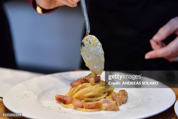 One of the chefs of the traditional team prepares the traditional famous Italian pasta dish "spaghetti alla carbonara", during a preview for the...