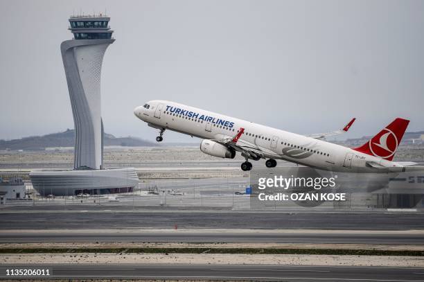 Turkish Airlines Airbus A321 plane takes off in front of the control tower at Istanbul Airport on the first day after moving from Ataturk...