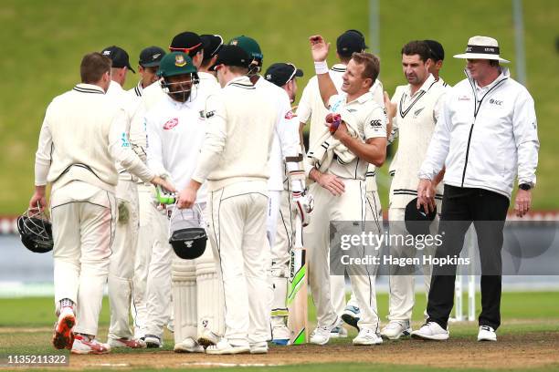 Neil Wagner of New Zealand celebrates with teammates after taking the wicket of Ebadat Hossain of Bangladesh to win the second test match in the...