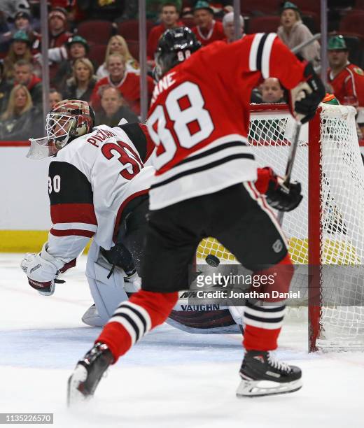 Patrick Kane of the Chicago Blackhawks pushes the puck past Calvin Pickard of the Arizona Coyotes to score a second period goal at the United Center...